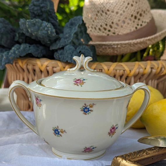 Elefántcsontszínű, virágokkal díszített porcelán teáskanna és cukortartó
