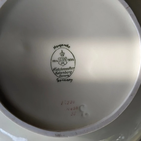 Elefántcsontszínű, virágokkal díszített porcelán teáskanna és cukortartó