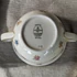 Elefántcsontszínű, virágokkal díszített porcelán teáskanna és cukortartó